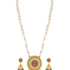A traditional Indian necklace set with gold-colored metalwork and synthetic stones, accompanied by matching earrings, displayed on a white fabric surface.
