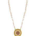 A traditional Indian necklace set with gold-colored metalwork and synthetic stones, accompanied by matching earrings, displayed on a white fabric surface.