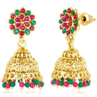 A traditional Indian necklace set with gold-colored metalwork and synthetic stones, accompanied by matching earrings, displayed on a white fabric surface.